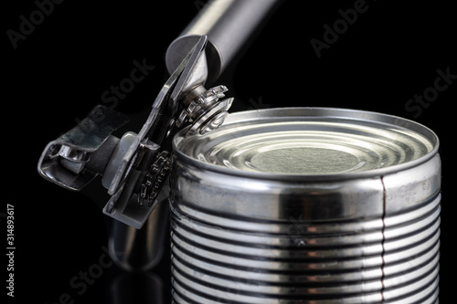 Foto a handmade can opener from Finland next to a can on a black background