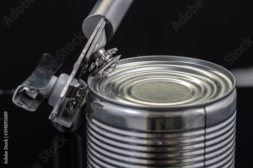 Foto a handmade can opener from Finland next to a can on a black background