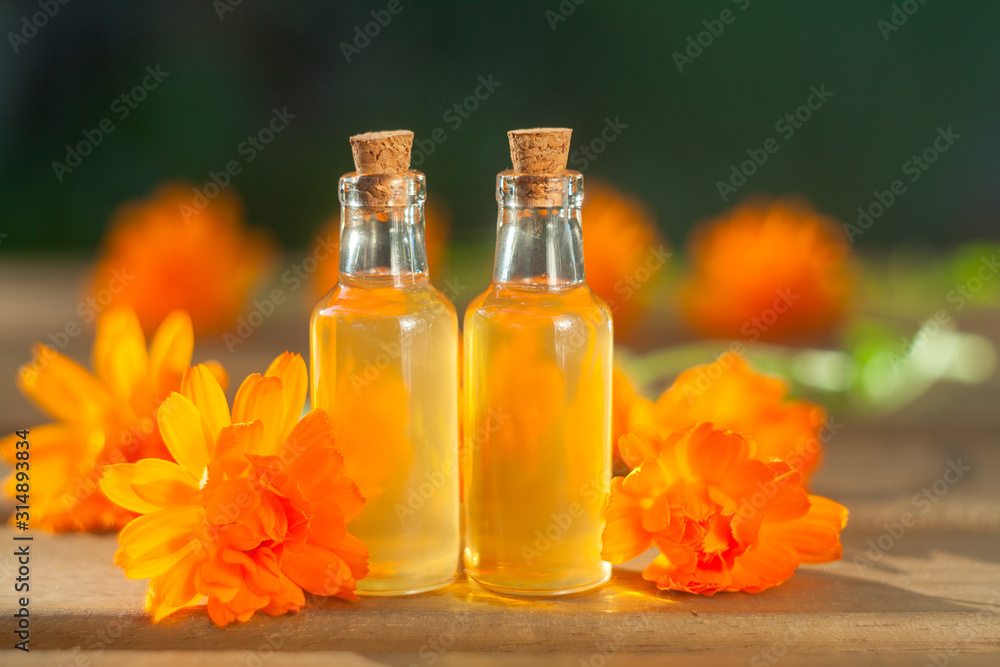 Essence of lavender flowers on table in beautiful glass bottle Essence of lavender flowers on table in beautiful glass bottle