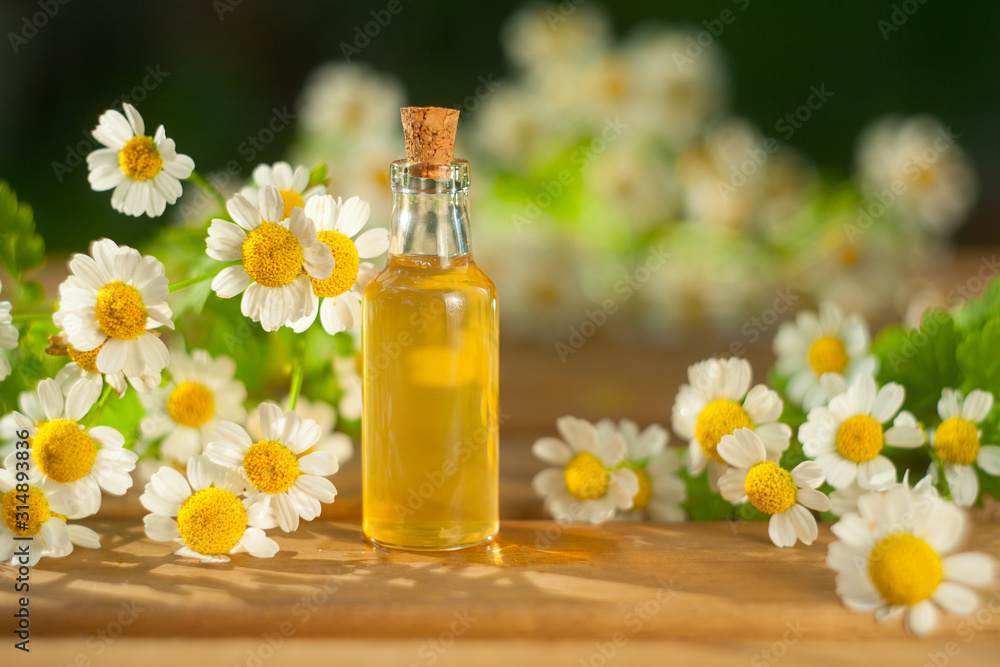 Essence of flowers on table in beautiful glass bottle Essence of flowers on table in beautiful glass bottle