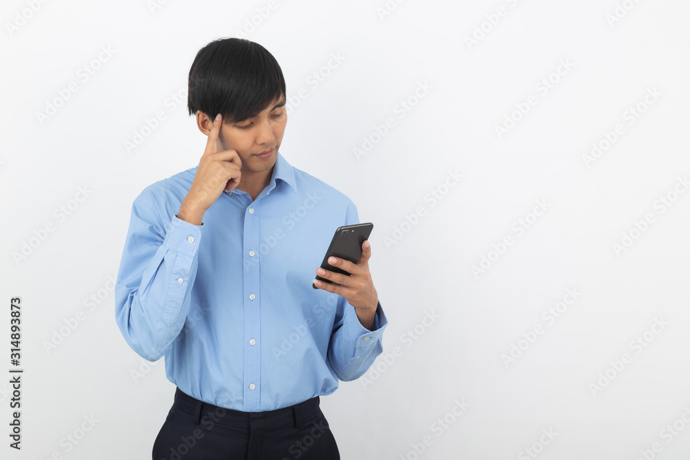 Young handsome asian business man playing smartphone and thinking isolated on white background. Young handsome asian business man playing smartphone and thinking isolated on white background.
