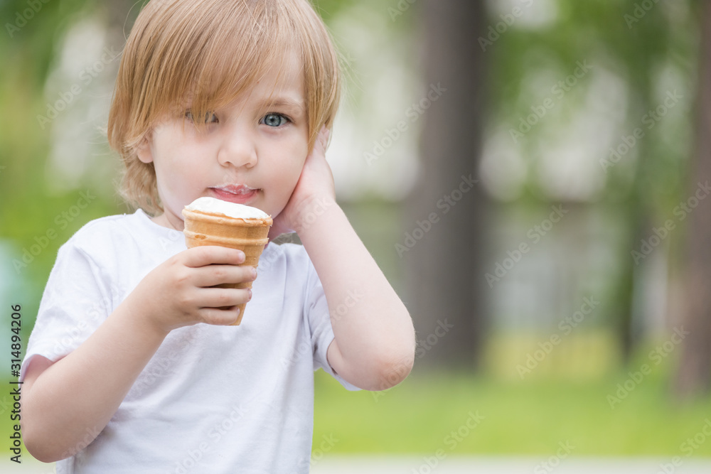 Beautiful baby with blue eyes in white tshirt is eating glass of white ice cream. Beautiful baby with blue eyes in white tshirt is eating glass of white ice cream.