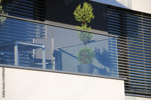 Print op canvas Balcony railings made of glass and stainless steel, behind them windows with mod