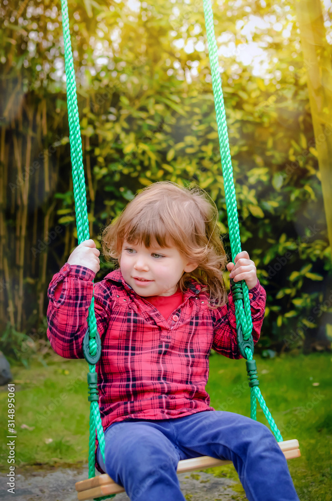 adorable little girl playing in the garden with her swing adorable little girl playing in the garden with her swing