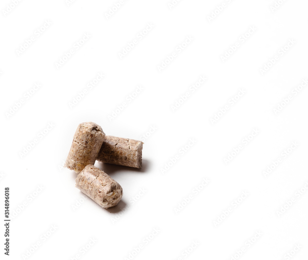 Pressed wood filler granules absorb odor, for pet toilet. Pressed wood pellets as an alternative fuel. isolate on a white background. Closeup