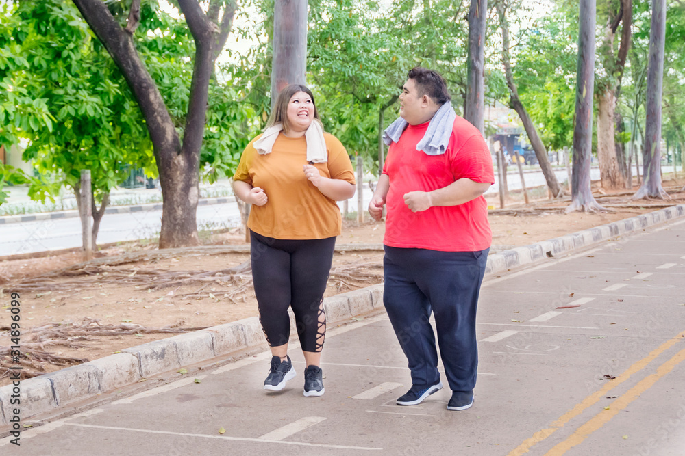 Obraz premium Fat Asian couple chatting joyfully while jogging