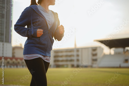 jogging, fitness, running, exercise, lifestyle, healthy concept. Young women warm up body. Sit back and Drink whey protein rest after running jogging on the running track around the football field. photo