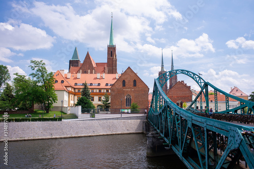 Wroclaw Poland view at Tumski island and Cathedral of St John the Baptist with bridge through river Odra. Picturesque landscape summer day blue sky white cloud.
