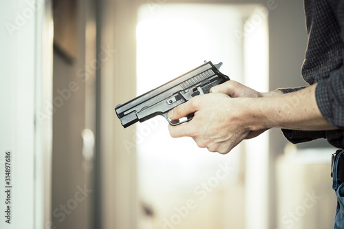 Police undercover weapon concept: Man is holding black weapon in his hand photo