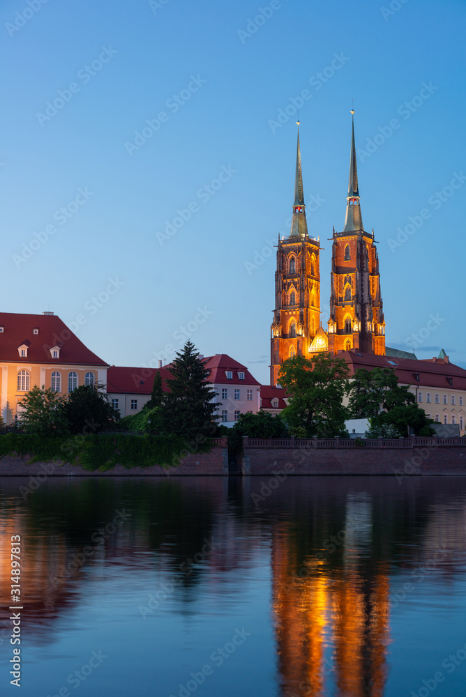 Naklejka premium Sightseeing of Poland. Cityscape of Wroclaw, beautiful night view. The view at Tumski island and Cathedral of St John the Baptist, Church of Our lady on the Sand, Odra river.