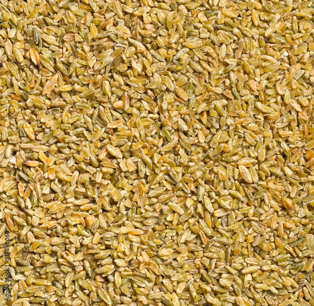 Uncooked, raw freekeh or firik, roasted wheat grain, texture background top view flat lay