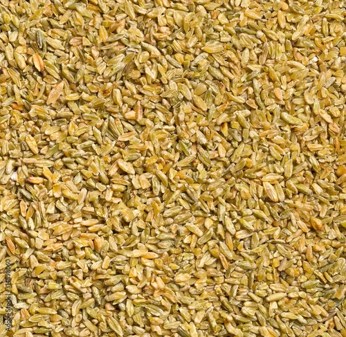 Uncooked, raw freekeh or firik, roasted wheat grain, texture background top view flat lay