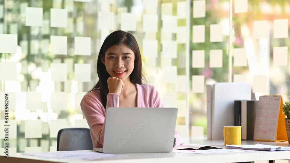 Portrait photo of young creative woman smiling moment and looking at camera. Happiness working concept. Portrait photo of young creative woman smiling moment and looking at camera. Happiness working concept.