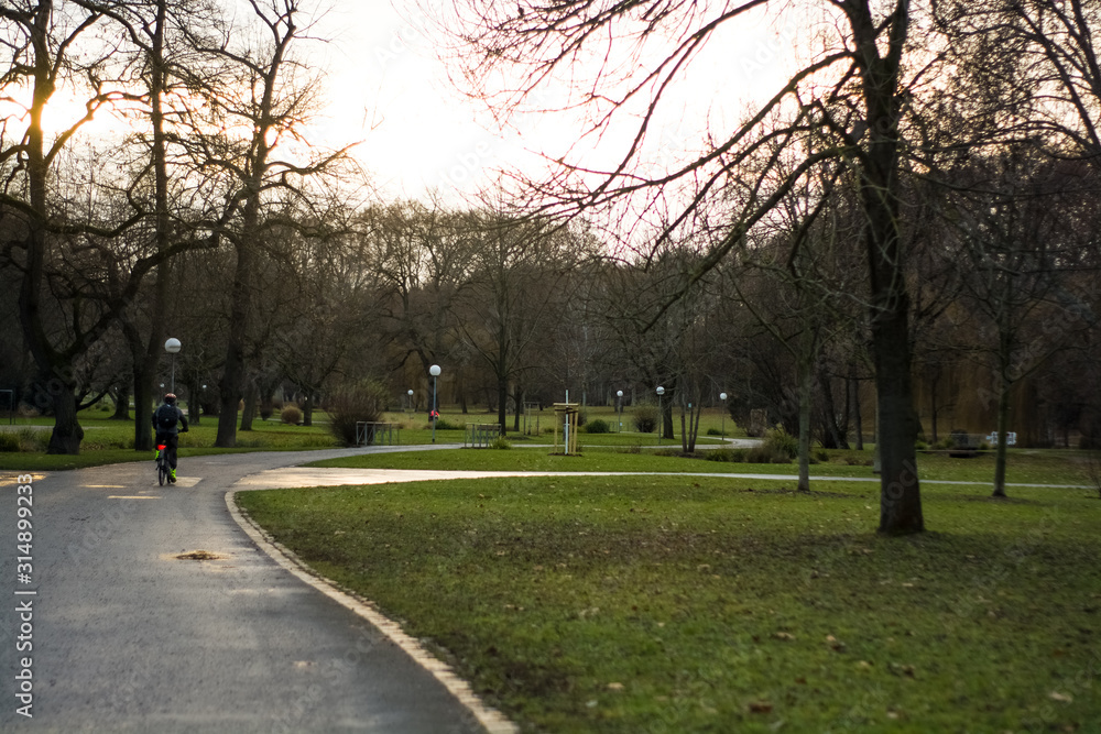 Green spring park with paths and bike paths. Infrastructure. Place for rest and entertainment. Nature. Background.