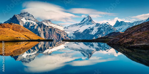 Panoramic morning view of Bachalp lake / Bachalpsee, Switzerland. Majestic autumn scene of Swiss alps, Grindelwald, Bernese Oberland, Europe. Beauty of nature concept background. photo