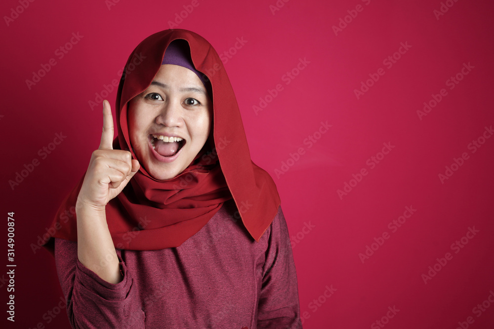 Muslim Woman Having Bright Idea, Looking at Camera Smiling and Pointing Up Muslim Woman Having Bright Idea, Looking at Camera Smiling and Pointing Up