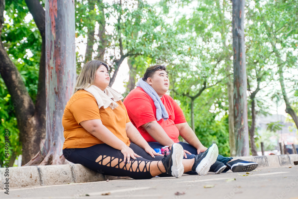 Fat Asian couple taking a break after working out Fat Asian couple taking a break after working out