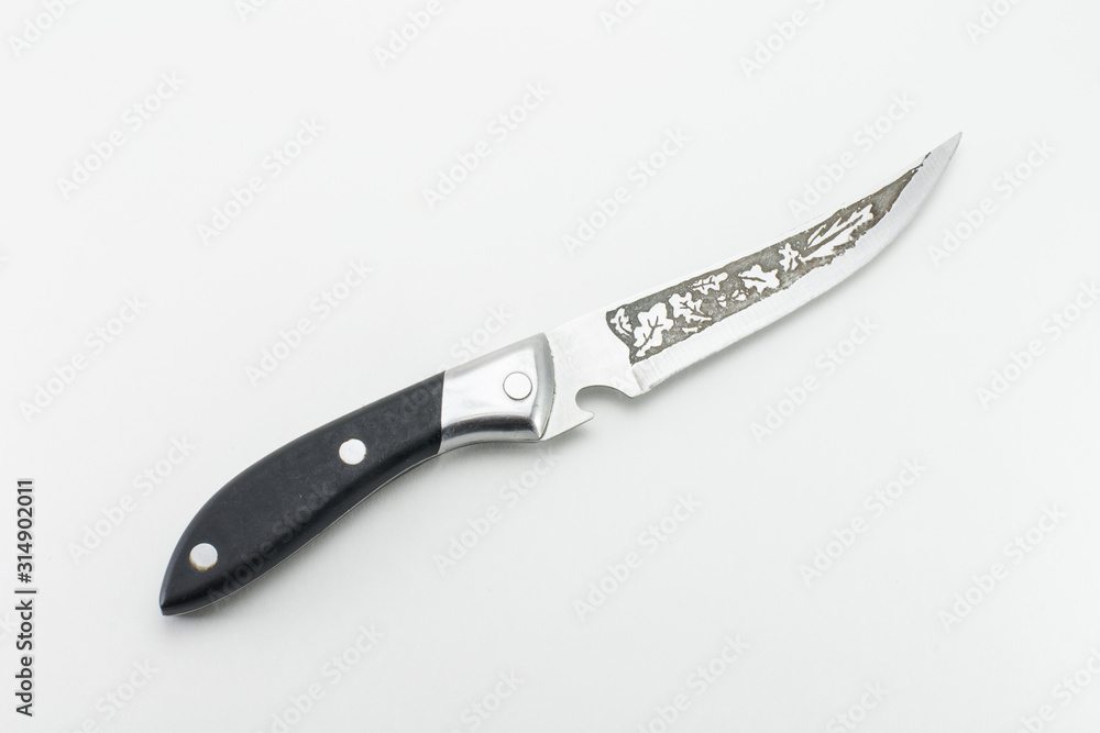 Obraz premium Kitchen knife with a black hilt. Patterns in the form of oak leaves on a blade.