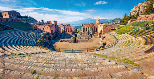 Fototapeta Naklejka Na Ścianę i Meble -  Panoramic morning view of Taormina town and Etna volcano on background. Picturesque spring view of ancient Greco-Roman theater, Sicily, Italy, Europe. Traveling concept background.