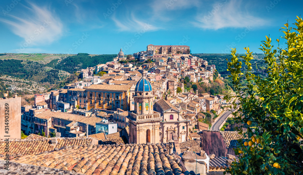 Sunny spring cityscape of Ragusa town with Palazzo Cosentini and Duomo di San Giorgio church on background. Nice afternoon scene of Sicily, Italy, Europe. Traveling concept background.
