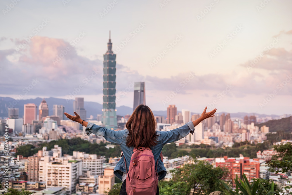 Obraz premium Young woman traveler looking beautiful cityscape at sunset in Taipei, Travel lifestyle concept