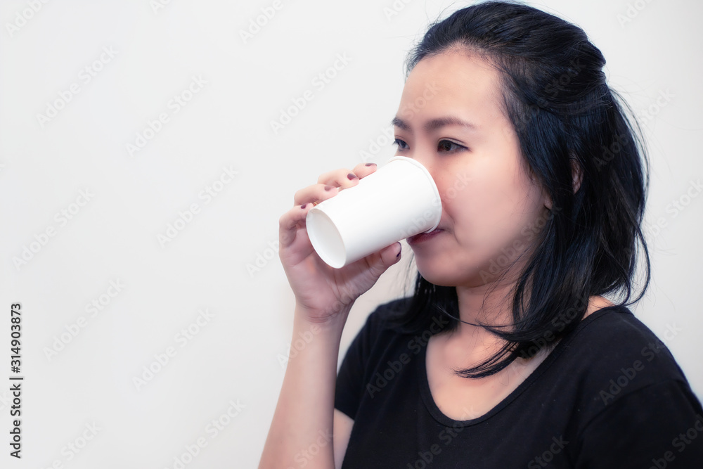 Asian young woman drinking a fresh white paper cup of water or other beverage. Asian young woman drinking a fresh white paper cup of water or other beverage.