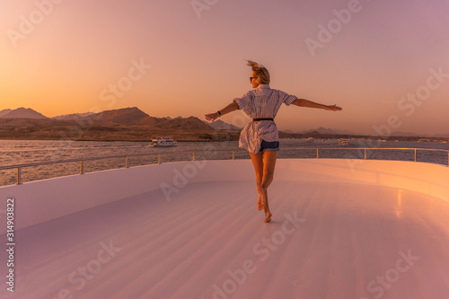 female run on a yacht and under the sunlight at sunset