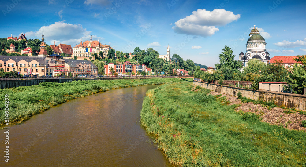 Fototapeta premium Adorable morning cityscape of Sighisoara with Sighisoara City Hall and Holy Trinity Church on background. Attractive summer view of medieval town of Transylvania, Romania, Europe.