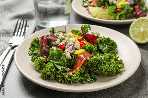 Tasty fresh kale salad on grey table