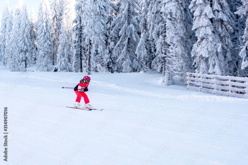 Young skier in motion, skiing in mountain ski resort during winter vacation
