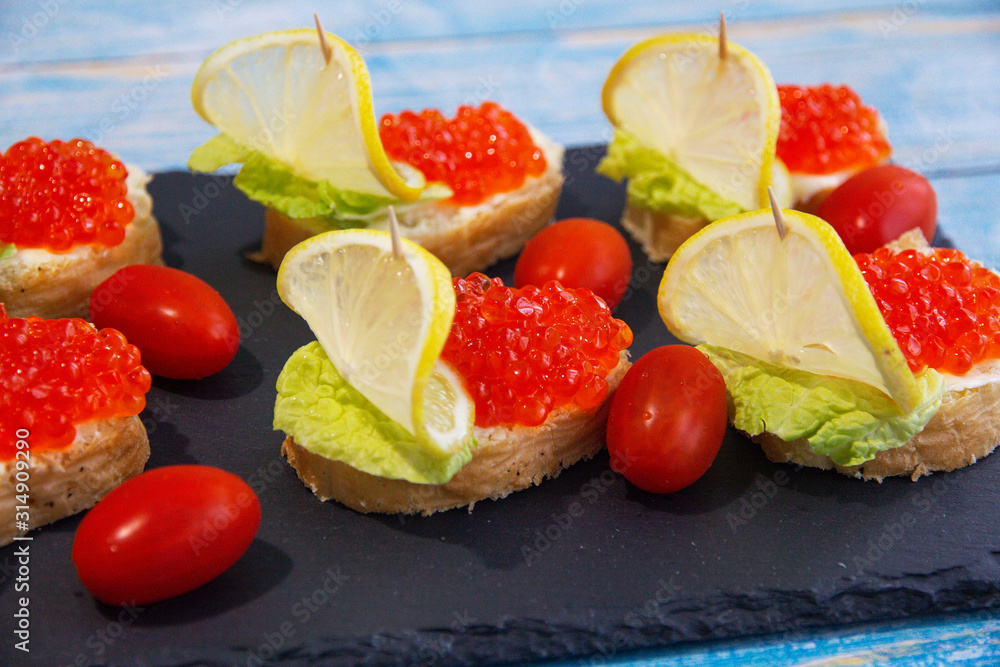 Red caviar sandwich with lemons and tomatoes Red caviar sandwich with lemons and tomatoes