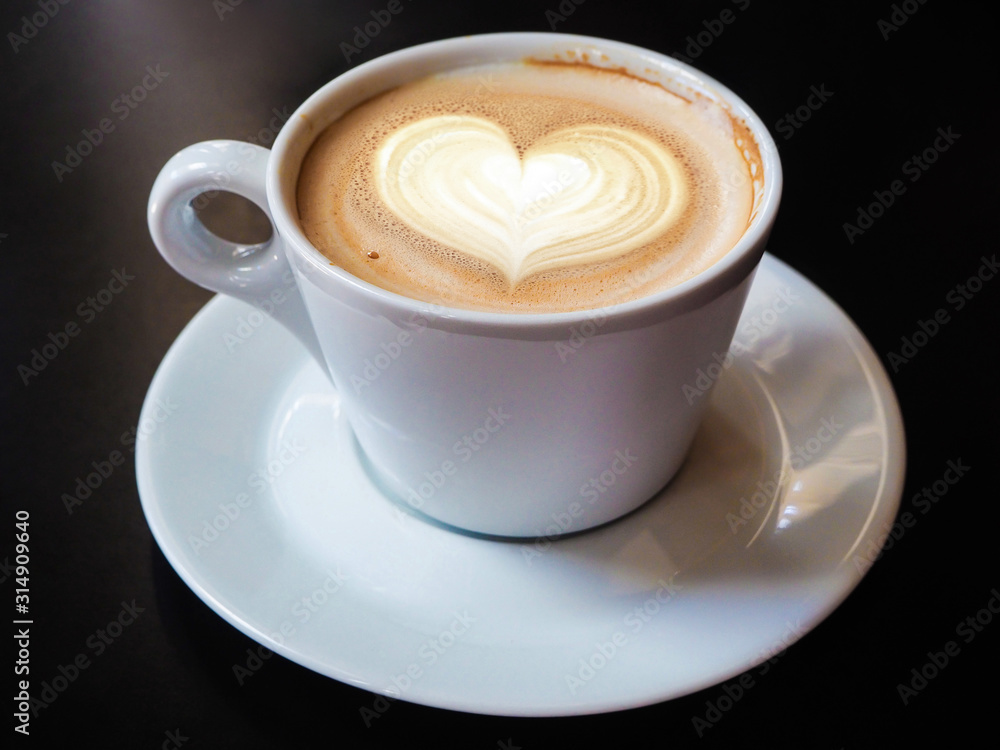 Cup of latte coffee with heart symbol on black background Cup of latte coffee with heart symbol on black background