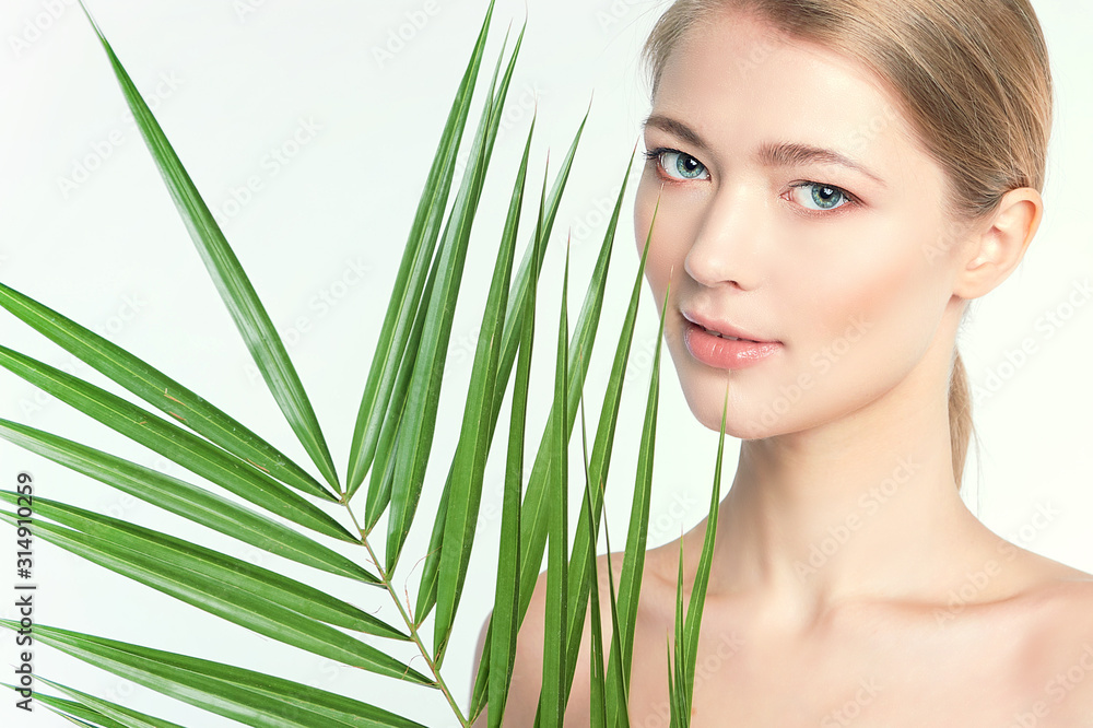 Fototapeta premium Natural organic skin care, the concept of harmony with nature, green long fern leaves grass near the face. portrait of beauty ladies. Young beautiful woman with clean sparkling skin of face and body