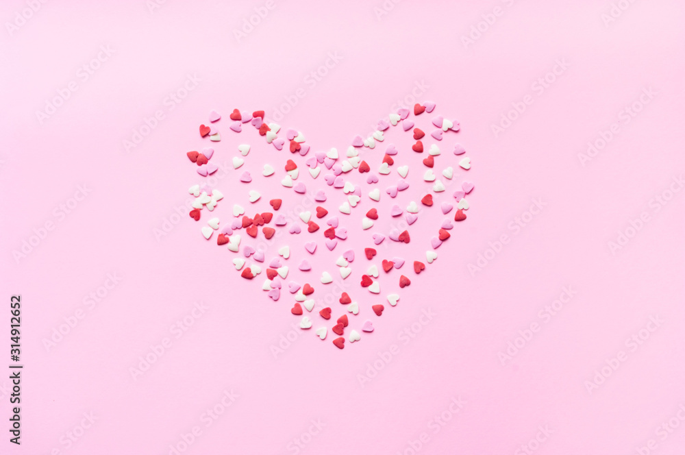 Valentines Day. Heart shape formed of sweet confetti on pink background. Template mock up of greeting card or text design. Close-up