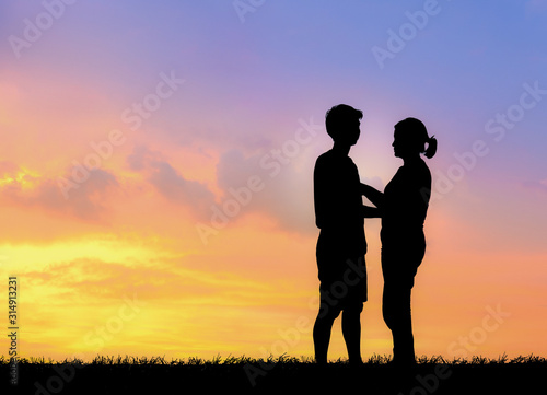 Silhouette of lovely couple holding by hands on beautiful sunset © showcake
