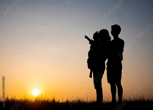 Silhouette family,father, mother and children against the sunset.