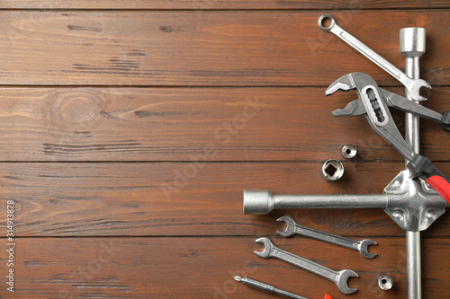 Auto mechanic's tools on wooden background, flat lay. Space for text