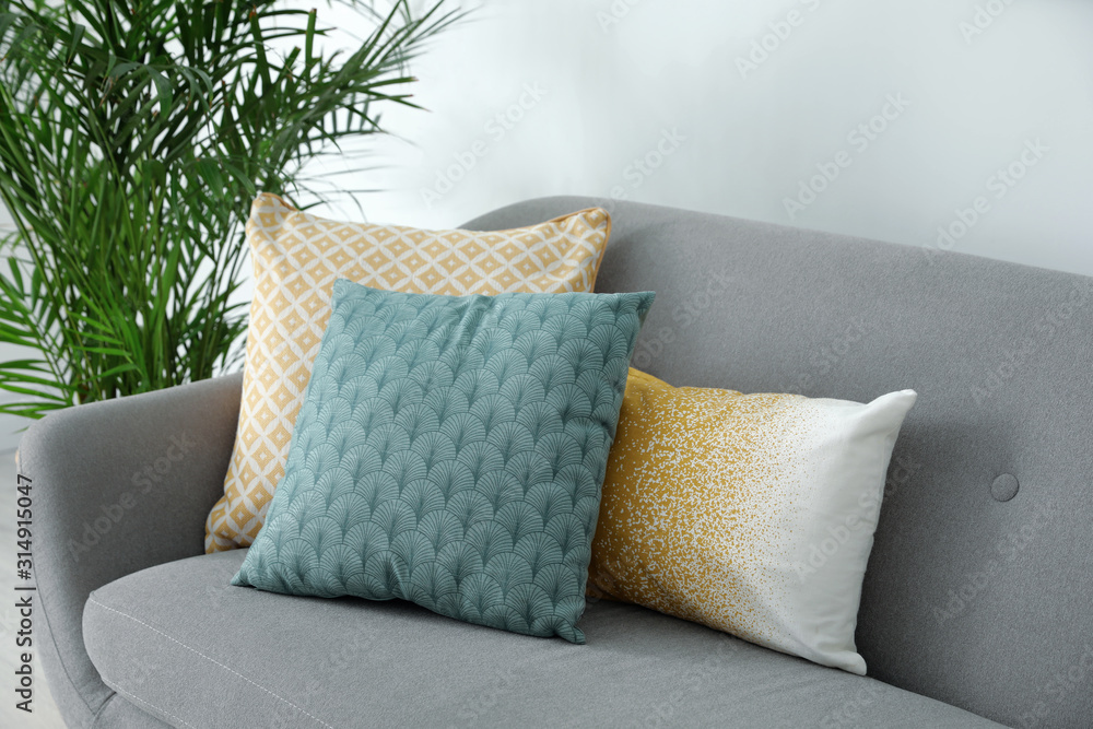 Different soft pillows on sofa in living room - obrazy, fototapety, plakaty 