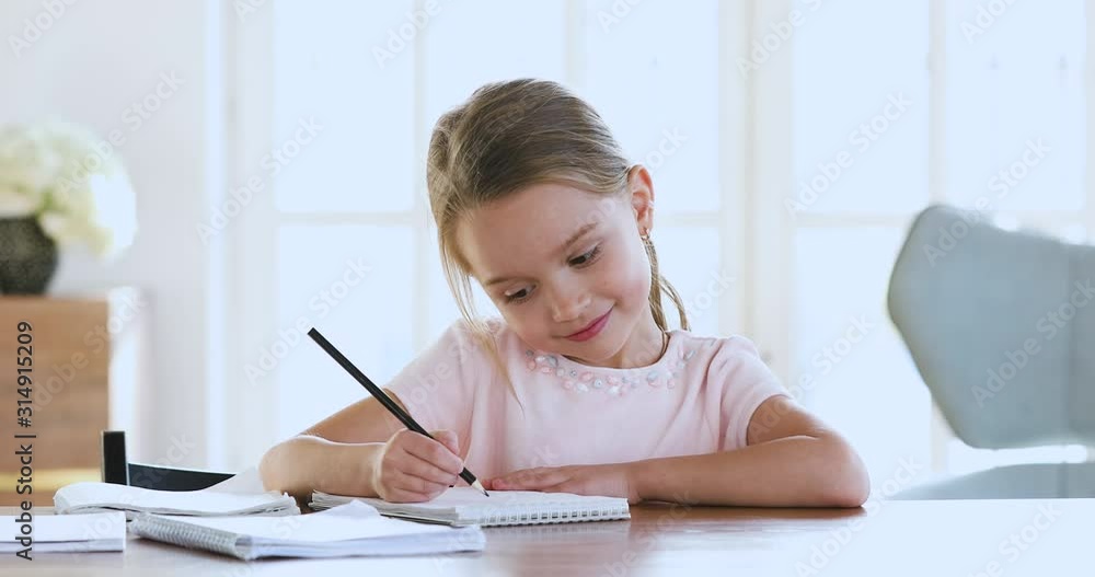 Cute smart school child girl learning writing doing math homework Cute smart school child girl learning writing doing math homework