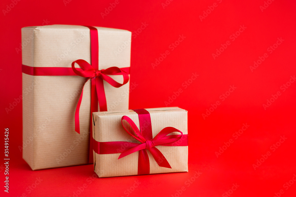 Two Brown gift boxes with red ribbons on Red background. Gift for Christmas, Valentine day or a birthday. Two Brown gift boxes with red ribbons on Red background. Gift for Christmas, Valentine day or a birthday.