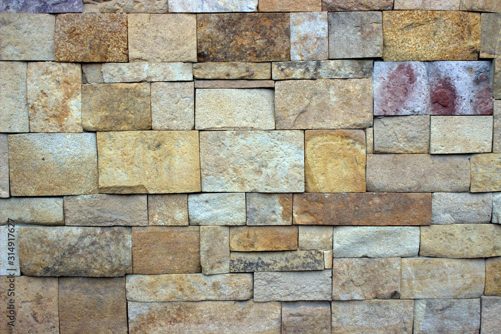 Fototapeta premium Stonework of rectangular stones in gray-brown tones. Retro style murals