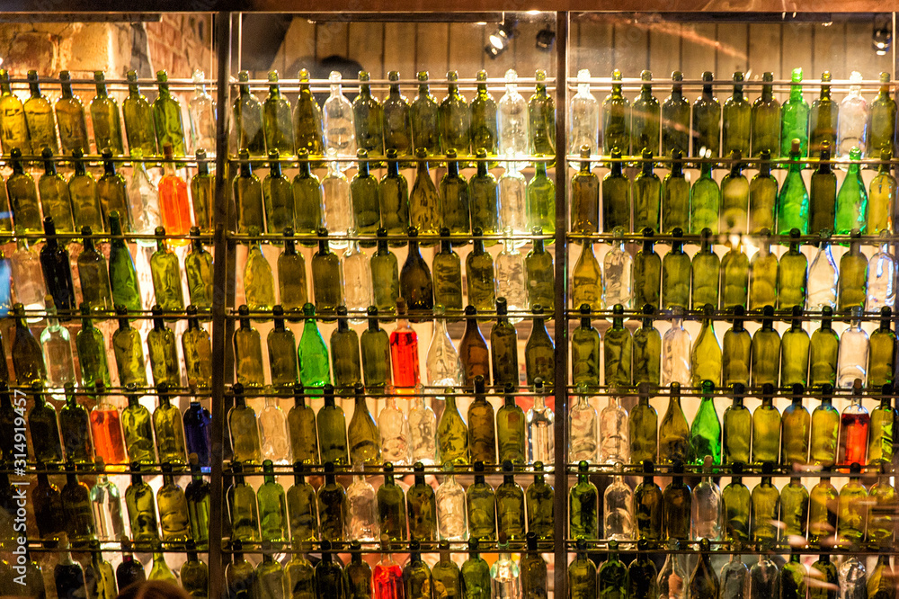 Empty wine bottles in backlight. Unusual wine cellar or bar design
