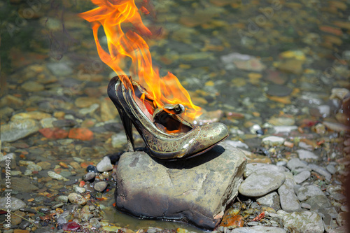 women's high-heeled shoes stand on a stone and burn