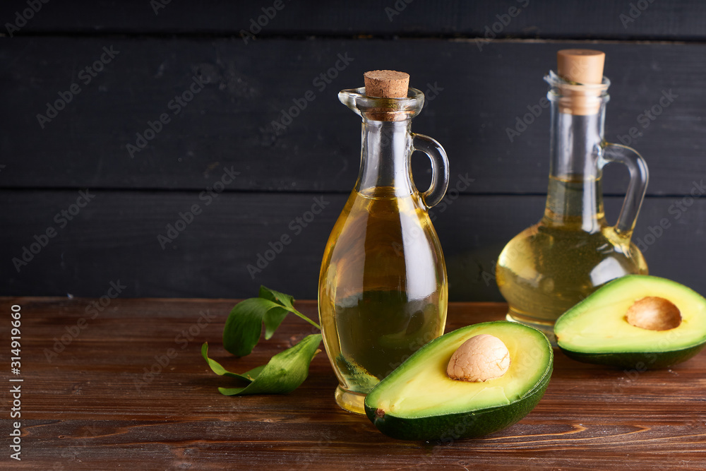 Healthy Avocado oil in glass bottles. Dark background Copy space Healthy Avocado oil in glass bottles. Dark background Copy space