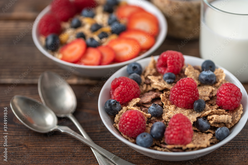 Granola chips with blueberries and raspberries in white bowl. Granola chips with blueberries and raspberries in white bowl.