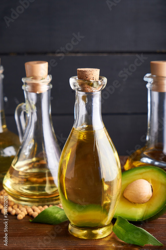 Useful vegetable oils in glass bottles. Avocado oil, chickpea oil, peanut oil, almond oil. Dark background