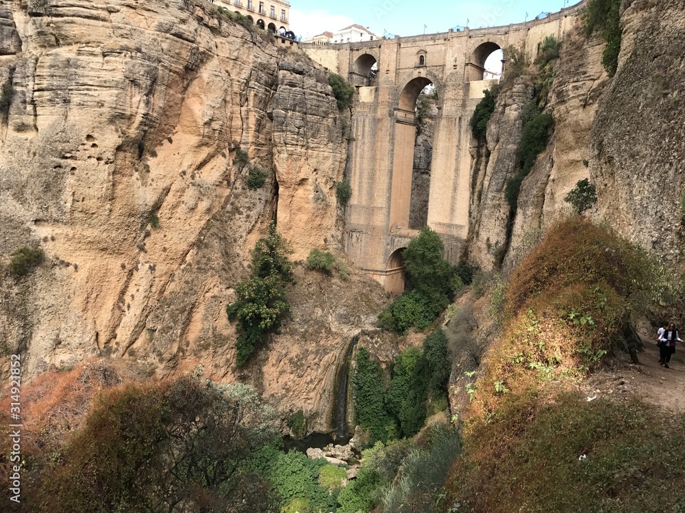 Bridge in Ronda famous and romantic Andalusia Spain. Photo from the viewing point under the bridge.  You can see the rocky cliffs of both sides of the bridge