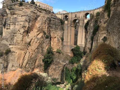 Bridge in Ronda famous and romantic Andalusia Spain. Photo from the viewing point under the bridge.  You can see the rocky cliffs of both sides of the bridge