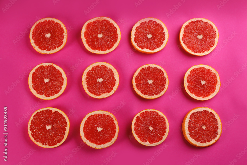 Flat lay composition with tasty ripe grapefruit slices on magenta background Flat lay composition with tasty ripe grapefruit slices on magenta background