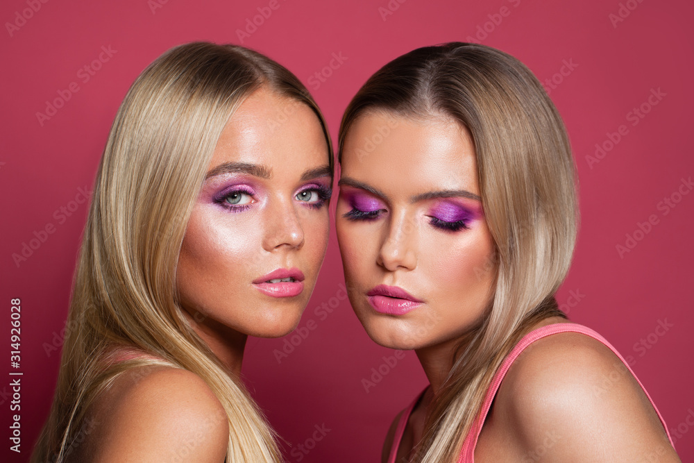 Pretty blonde women models with makeup on pink background close up portrait Pretty blonde women models with makeup on pink background close up portrait
